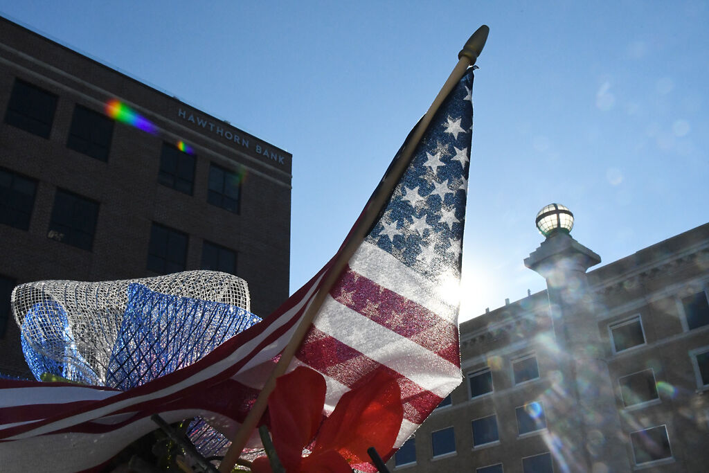 The sun shines through a miniature American flag on Wednesday at the Veterans Memorial.